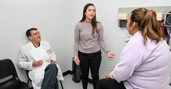 A woman talks to a patient in a doctor's office.